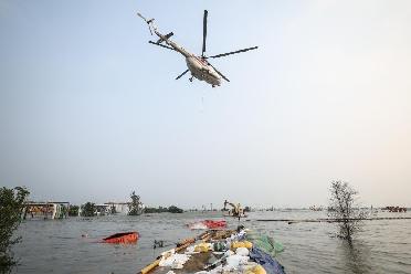 新華全媒+｜遼寧省盤(pán)錦市繞陽(yáng)河段潰口進(jìn)行直升機吊裝投放六角沉箱作業(yè)